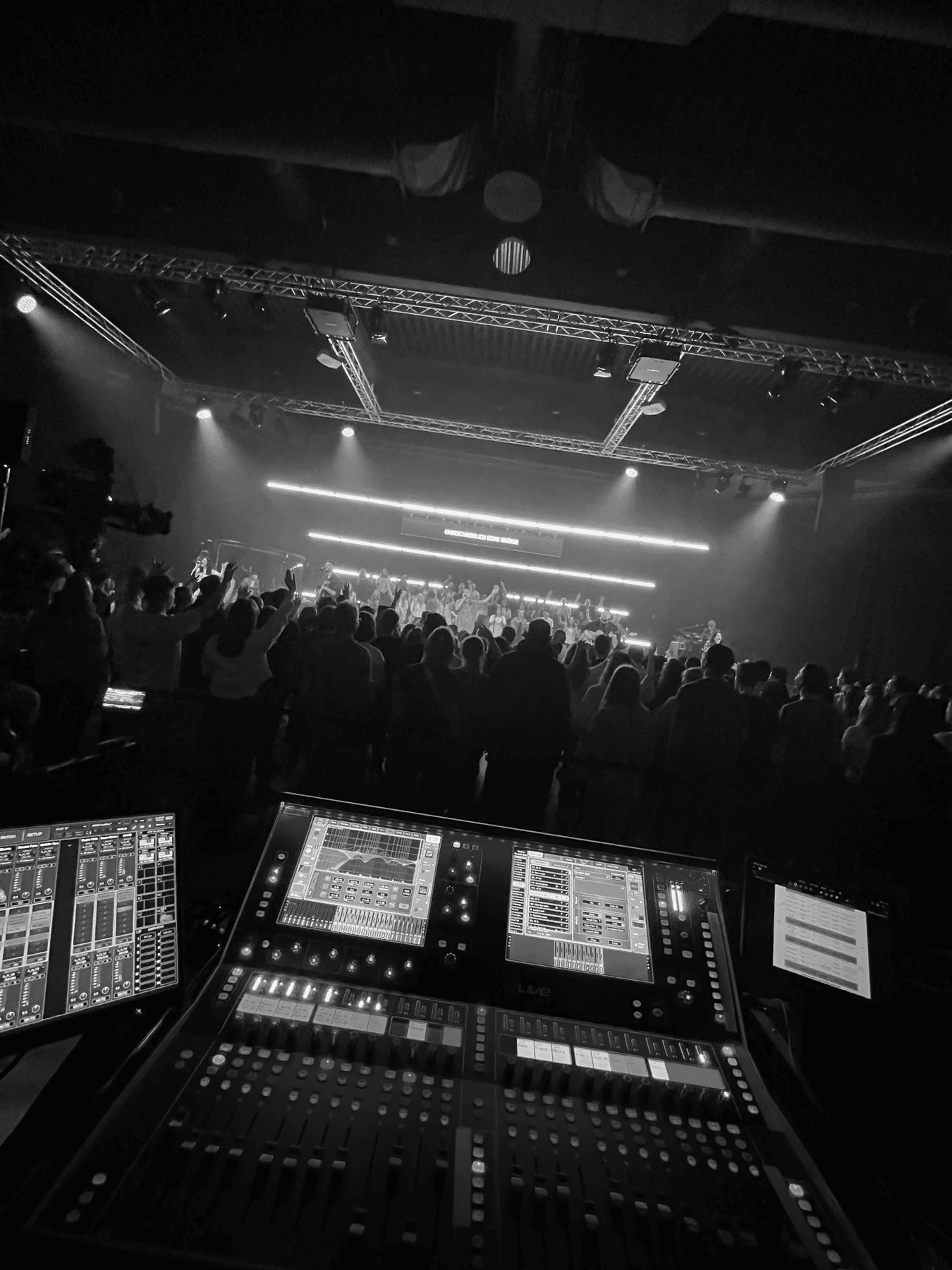 Live-Konzert mit Publikum, im Vordergrund ein digitales Mischpult